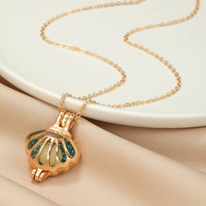 Gold hollow shell pendant necklace with blue crystals and luminous pearl on silk