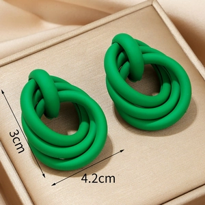 Neon green oversized interlinked hoop earrings with matte finish on silk background
