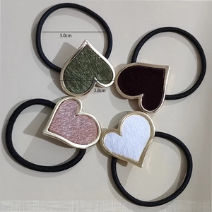 Detail view of heart-shaped elastic hair ties with gold frames in four different colors