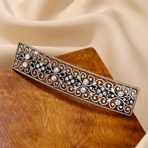 Vintage silver hollow-out hair clip with sparkling rhinestones on champagne satin