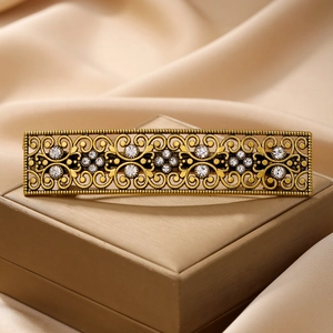 Vintage gold hollow floral hair clip with rhinestones on champagne silk background