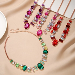 Détail de colliers avec gros strass colorés de formes variées sur fond en soie beige