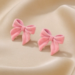 Boucles d'oreilles nœuds roses floqués sur fond élégant en soie beige pour femme