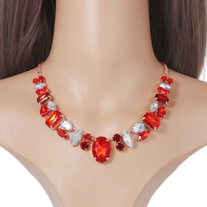 Détail du collier plastron doré rose orné de cristaux rouges et de pierres irisées