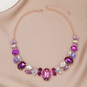 Détail d'un collier en or rose avec des strass violets et blancs aux coupes mixtes