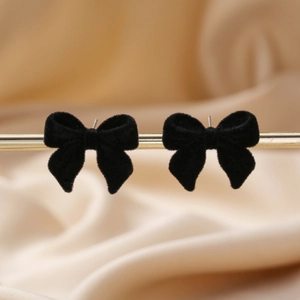 Boucles d'oreilles nœud floquées noires élégantes sur fond de soie au style moderne