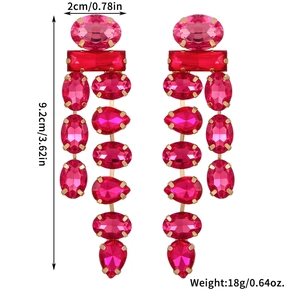 Detail view of long tassel earrings with pink gemstones and gold-plated metal claws