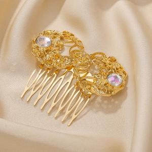 Macro detail of a golden vintage hair comb with intricate filigree and rainbow acrylic gems