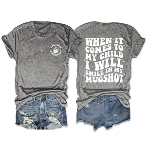 Flat lay of grey T-shirt with white back print and distressed blue denim shorts