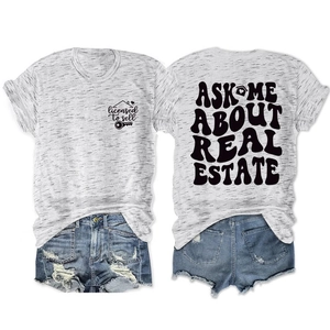 Flat lay of gray T-shirt with Ask Me About Real Estate print and blue denim shorts