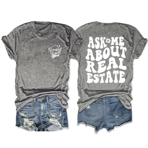 Close-up of double-sided Ask Me About Real Estate graphic print on a gray cotton t-shirt