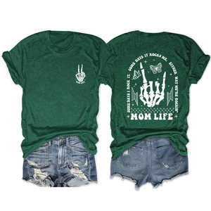 Flach liegendes Set aus grünem Mom Life T-Shirt und Jeans-Shorts mit Grafikdruck