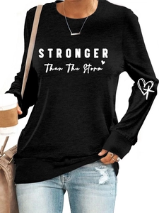 Detail of STRONGER than the storm print on black long sleeve sweatshirt with heart design