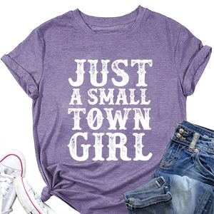 Détail d'un t-shirt violet avec texte Just A Small Town Girl et nœud élégant à l'ourlet