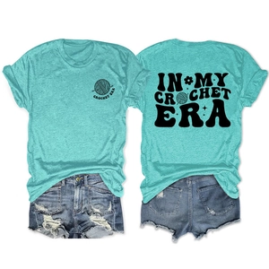 Vista fronte e retro della t-shirt blu In My Crochet Era con grafiche floreali vintage