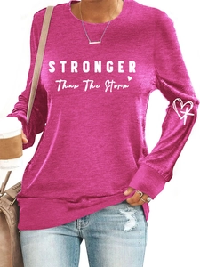 Detail of white STRONGER letter print and heart graphic on rose red long sleeve sweatshirt