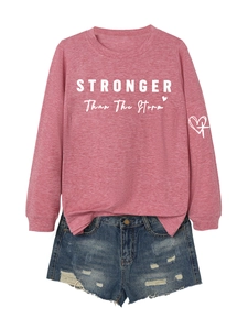 Detail of pink crewneck sweatshirt with STRONGER text and distressed denim shorts set