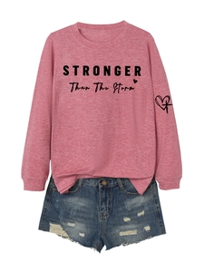 Detail of STRONGER than the Storm slogan and heart print on pink crewneck sweatshirt