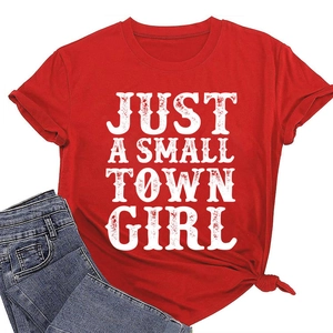 Détail du t-shirt rouge à col rond avec lettrage 'Just a small town girl' et nœud à la base