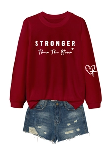 Detail of red crewneck sweatshirt with Stronger letter print and distressed denim shorts