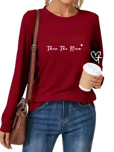 Detail of the white STRONGER Than The Storm print on a maroon long sleeve t-shirt