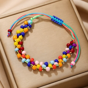 Détail d'un bracelet en perles fait main multicolore sur satin doré avec cordon bleu