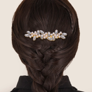 Détail d'un peigne à cheveux floral avec perles et strass sur tresse en épi