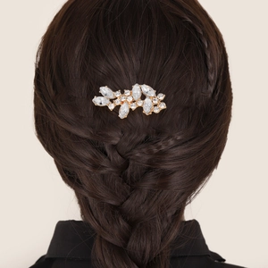 Détail d'un peigne à cheveux doré orné de cristaux dans un chignon tressé élégant
