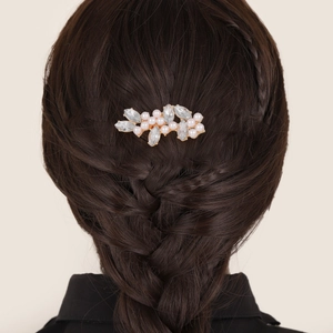Détail d'un peigne à cheveux doré avec cristaux et perles sur cheveux noirs