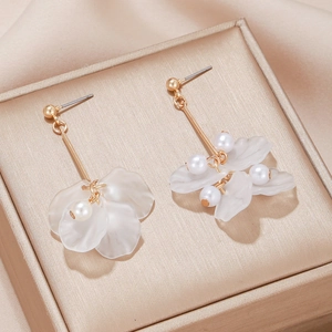 Élégantes boucles d'oreilles fleurs avec pétales dorés et perles sur boîte à bijoux