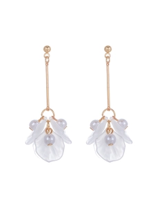 Détail de boucles d'oreilles pendantes avec tiges dorées, pétales blancs et perles