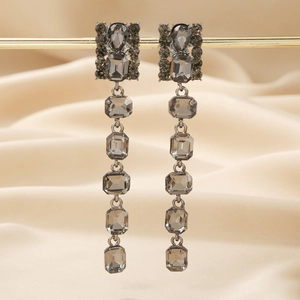 Elegant long charcoal grey tassel drop earrings with crystals on champagne silk background