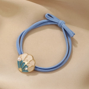Detail of marine-style elastic hair tie with shell charm, pearl, and starfish accents