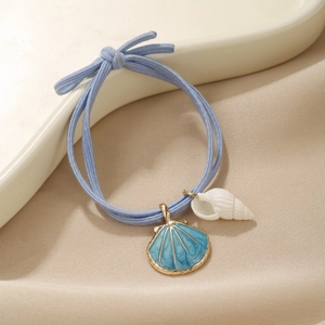 Macro shot of blue ocean style elastic hair tie with seashell and conch charms