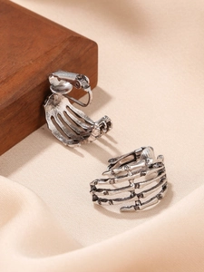 Detailed view of vintage silver skull hand clip-on earrings with antique metal finish