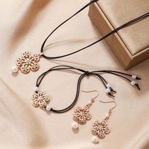 Elegantes Set aus roségoldenem Blumenschmuck mit weißen Perlen und schwarzer Kordel