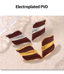Detail of PVD electroplated wave earrings in gold and silver with deep red enamel