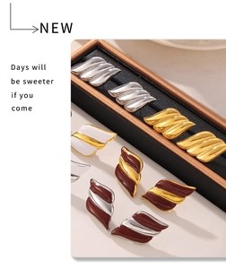 Close-up of wavy texture earrings in 18k gold plating and colorful enamel in a jewelry box