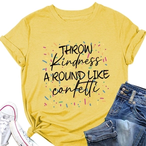 Détail du t-shirt jaune montrant le texte Throw Kindness et des motifs de confettis