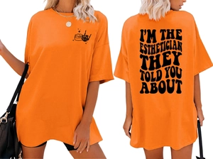 Front and back detail of bright orange oversize T-shirt with Esthetician graphic print
