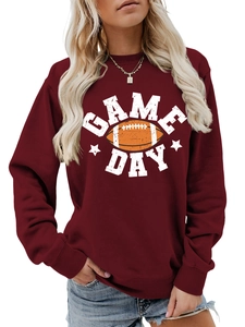 Close-up of Game Day text and rugby ball print on burgundy crewneck sweatshirt fabric