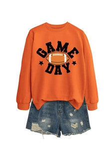 Flat lay of an orange Game Day sweatshirt paired with distressed blue denim shorts