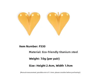 Détail de boucles d'oreilles cœur 3D dorées avec dimensions 2,4cm x 1,9cm et poids 7g
