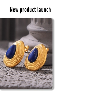 Macro shot of gold teardrop earrings featuring textured concentric lines and lapis lazuli stone