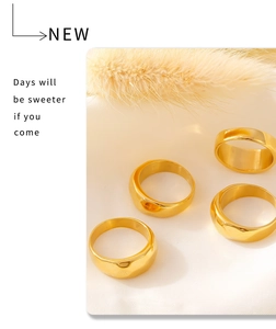 Detailed view of four minimalist 18k gold plated geometric rings on white fabric
