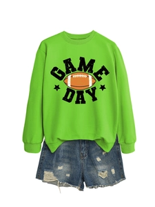 Flat lay of bright green Game Day sweatshirt paired with distressed blue denim shorts