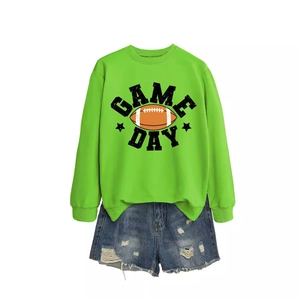 Kids green Game Day football sweatshirt paired with distressed blue denim shorts