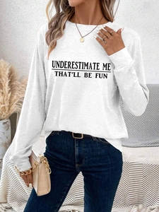 Detail of white long sleeve top featuring bold Underestimate Me That'll Be Fun typography
