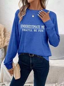 Detail of blue long sleeve tee with Underestimate Me print styled with denim