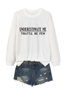Detail of white sweatshirt with Underestimate Me slogan and distressed denim shorts